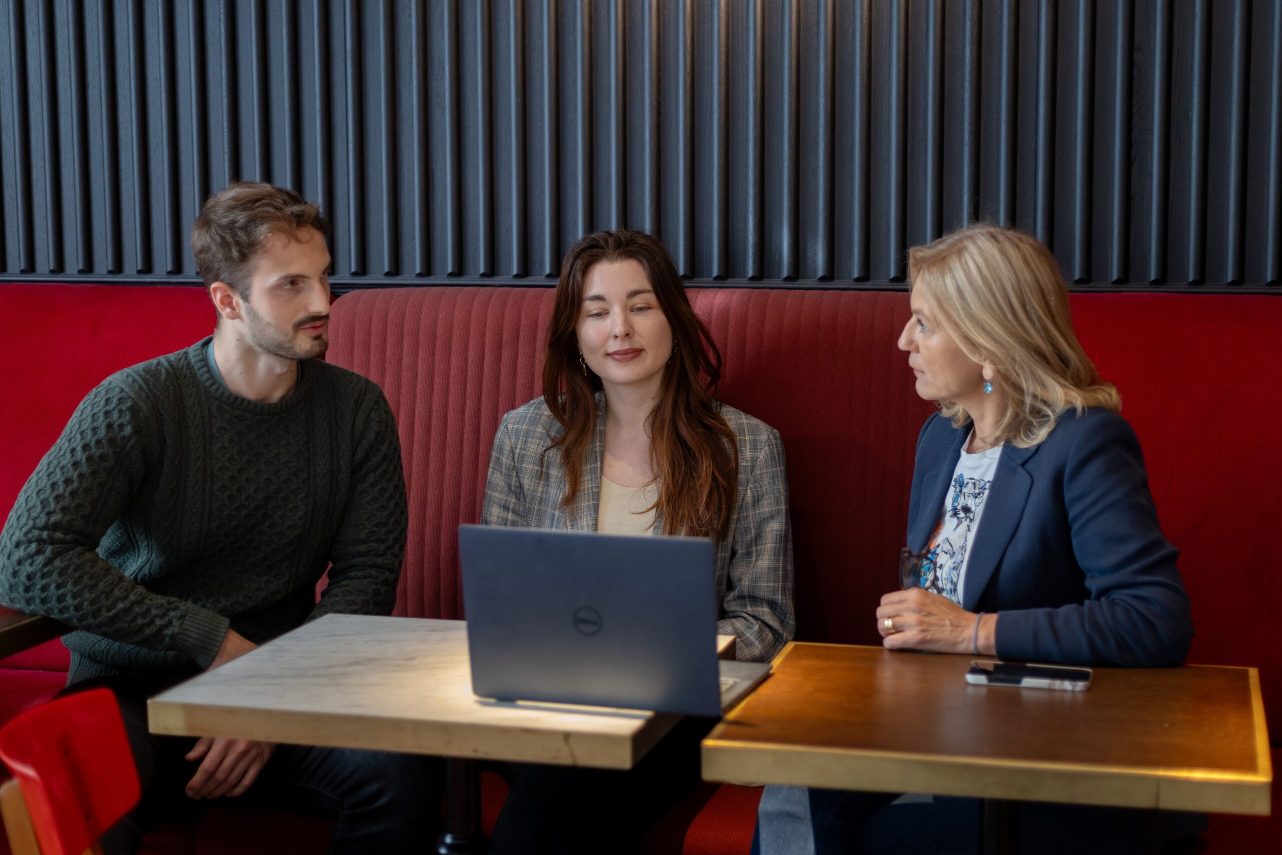 Three people discussing the contents of a laptop's screen