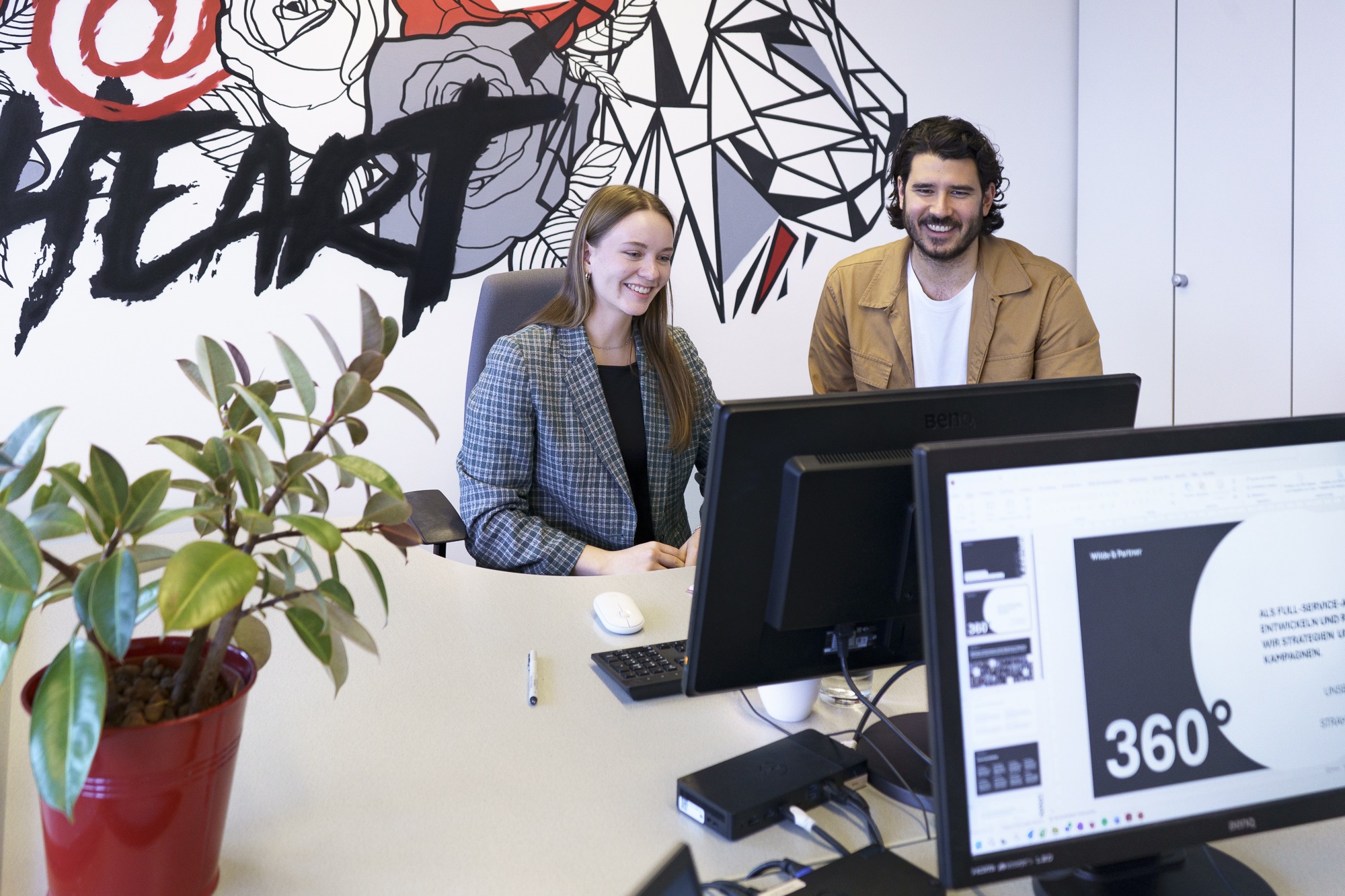 Two people working on a project in an office together